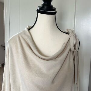 Cream Light weight sweater with bow and cold shoulder detail on left side.